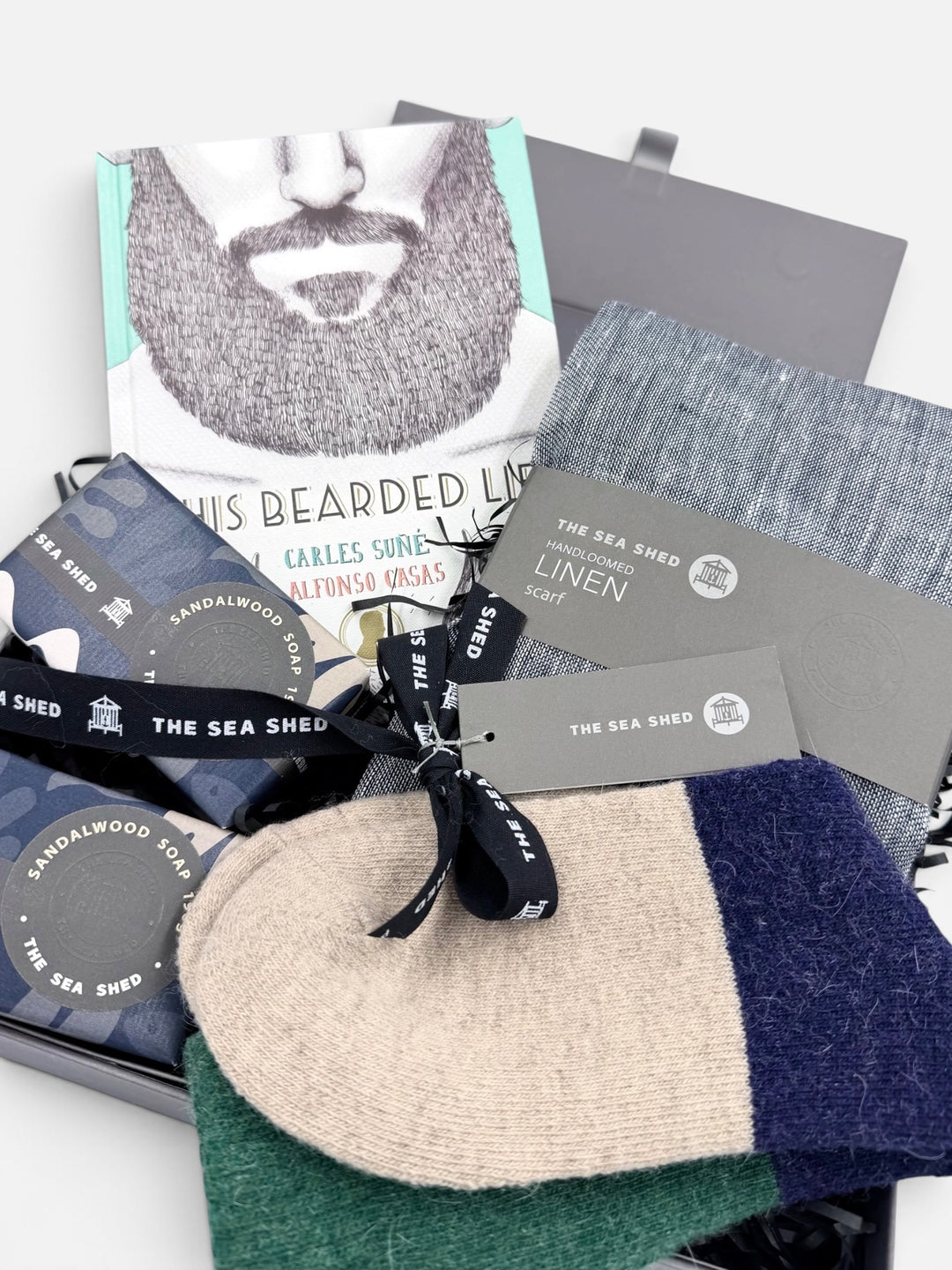 Close-up of the Bearded Life hamper with book, navy linen scarf, Sandalwood soaps and colour-block socks tied with Sea Shed ribbon